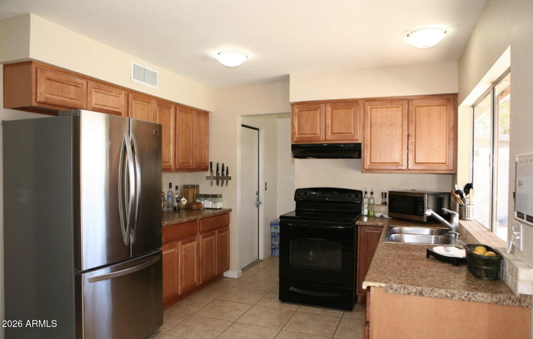 911 West Colgate Drive Tempe, AZ 85283 - Photo 5 of 15 a kitchen with a refrigerator stove and cabinets
