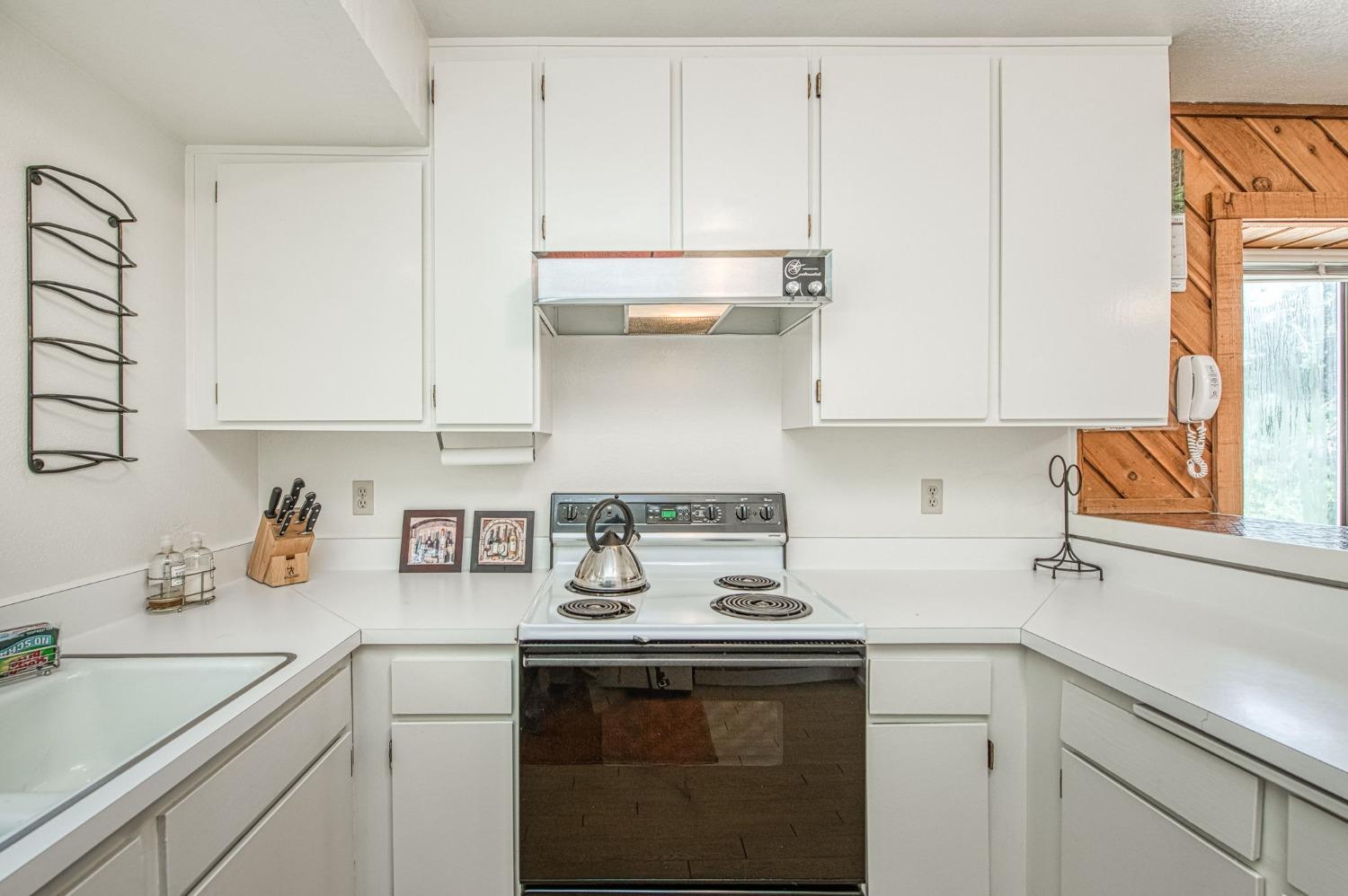 62721 Huntington Vista Road, Unit 119 Mono Hot Springs, CA 93642 - Photo 10 of 27 a kitchen with stainless steel appliances granite countertop a sink a stove and white cabinets