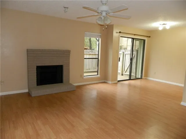 an empty room with windows and fireplace