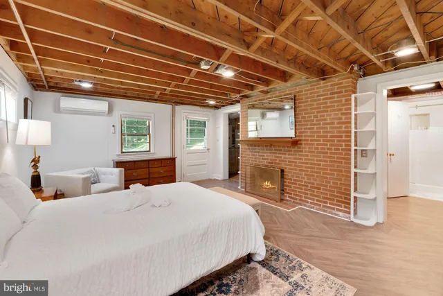 a bedroom with a bed a dresser next to a window