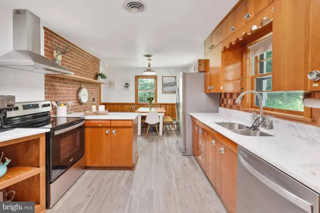 a kitchen with stainless steel appliances a sink stove and cabinets