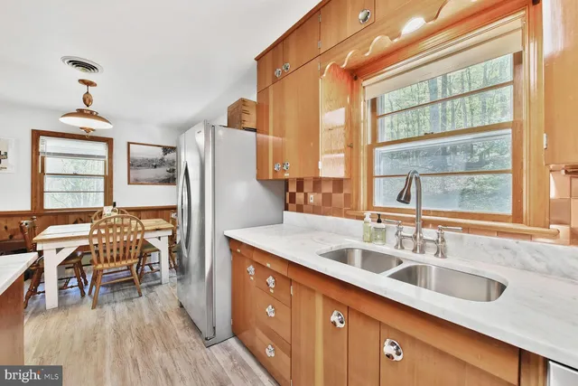 a kitchen with stainless steel appliances granite countertop a sink and a refrigerator
