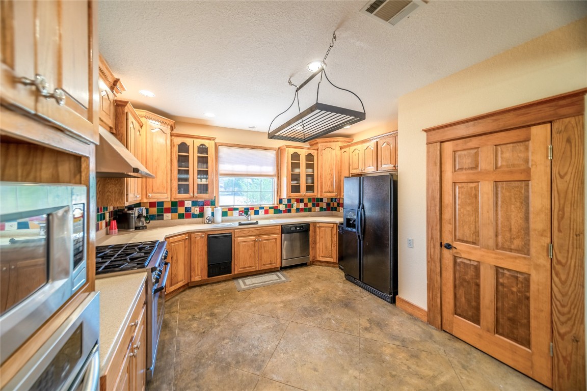 1428 Seven Spgs Drive Junction, TX 76849 - Photo 9 of 39 a kitchen with stainless steel appliances granite countertop a refrigerator and a stove top oven