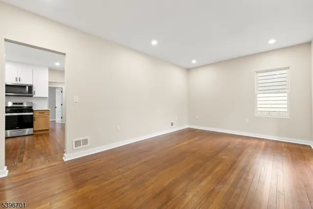 a view of a kitchen with wooden floor and electronic appliances