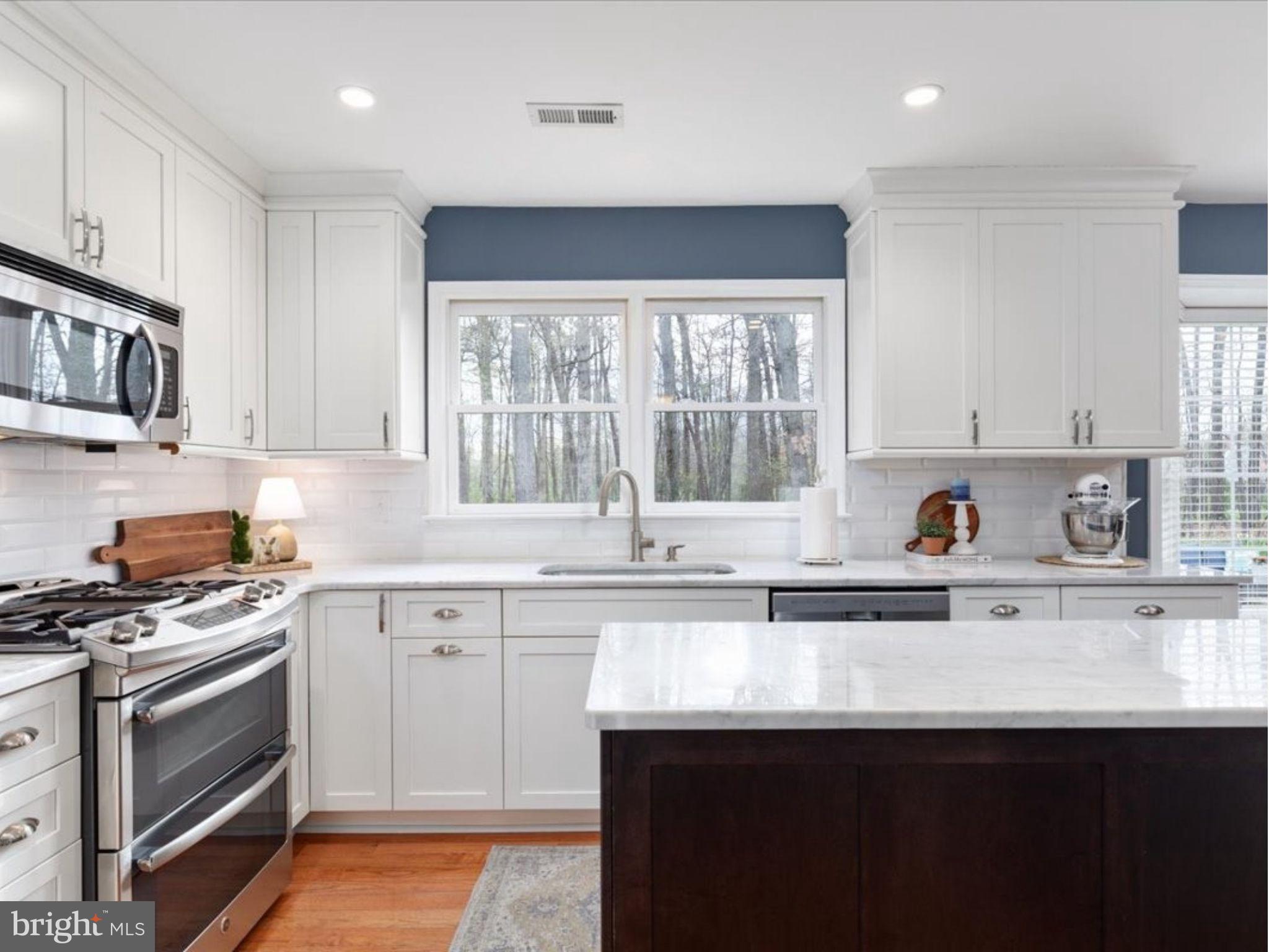 20299 Mustoe Place Ashburn, VA 20147 - Photo 12 of 45 a kitchen with stainless steel appliances granite countertop a sink dishwasher a stove and cabinets with wooden floor