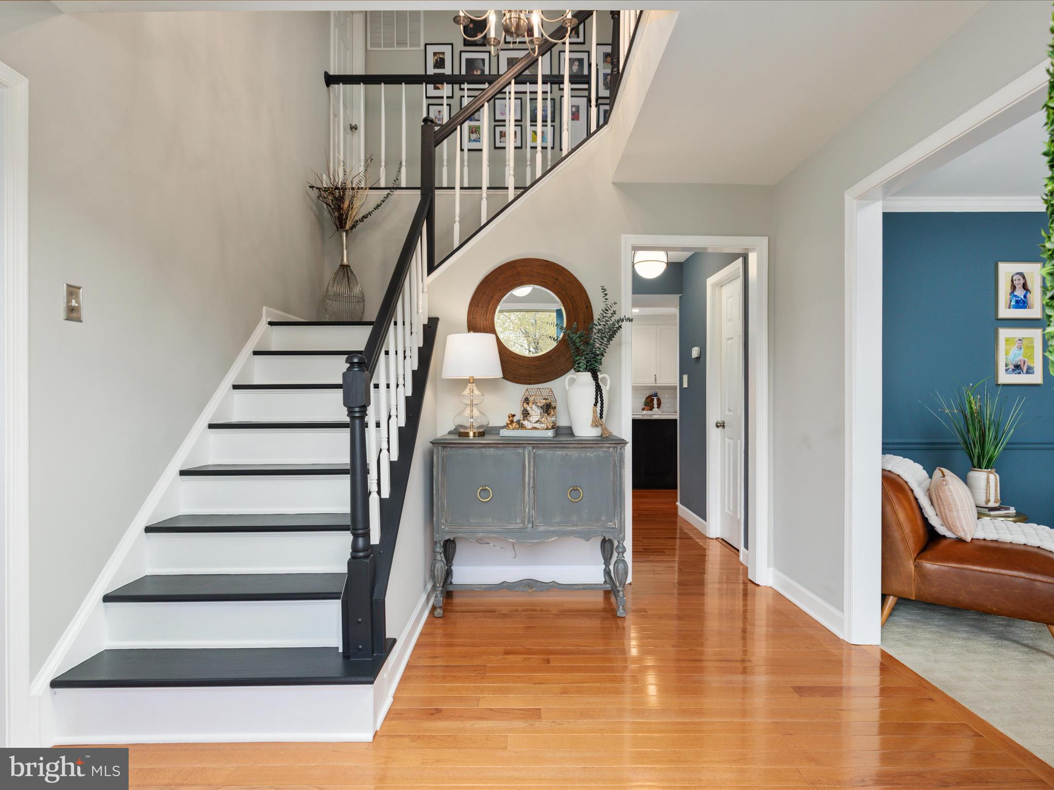 20299 Mustoe Place Ashburn, VA 20147 - Photo 3 of 45 a view of a hallway with wooden floor windows and a kitchen view