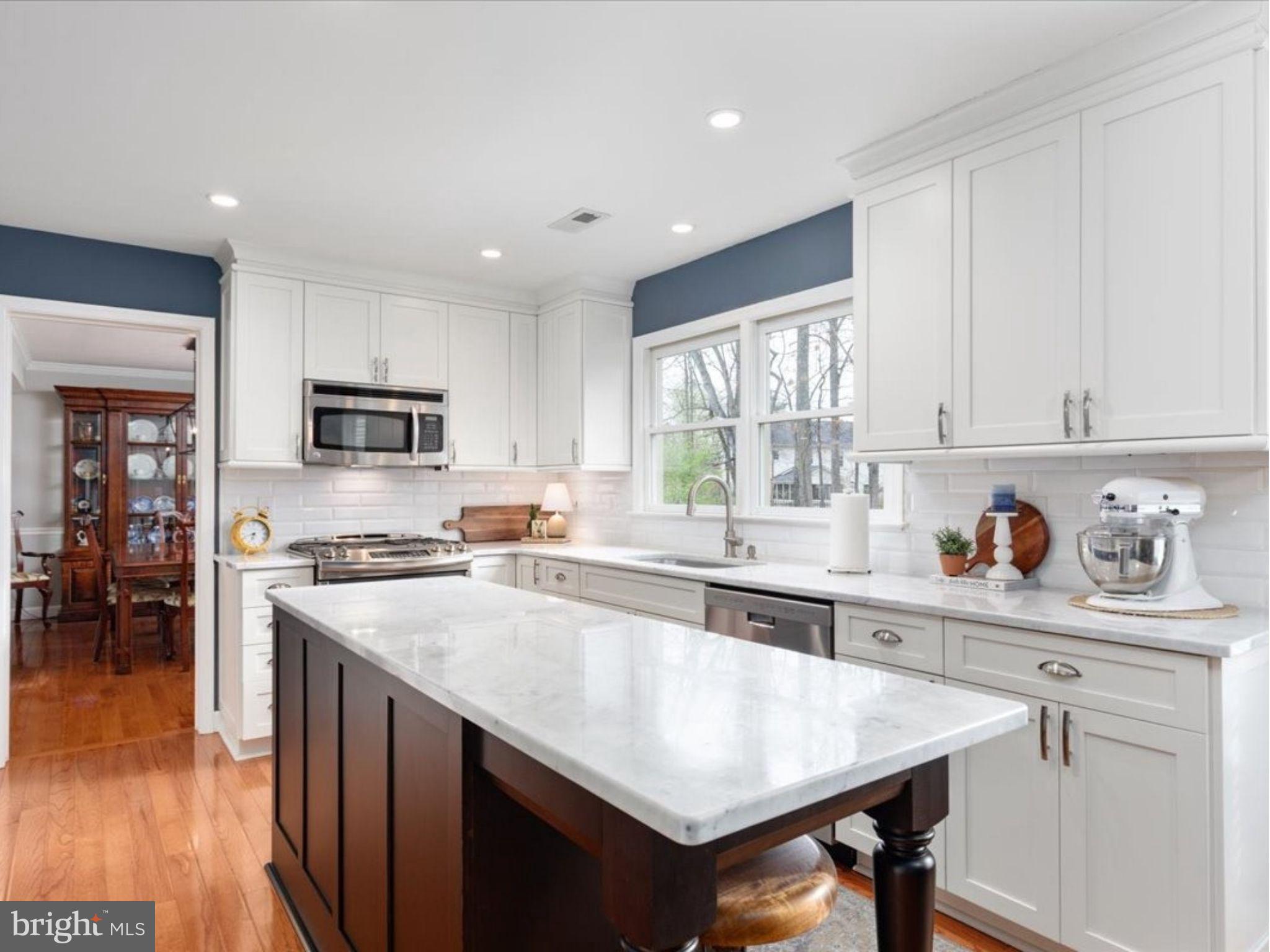 20299 Mustoe Place Ashburn, VA 20147 - Photo 10 of 45 a kitchen with stainless steel appliances granite countertop a stove top oven a sink dishwasher and a refrigerator with wooden floor