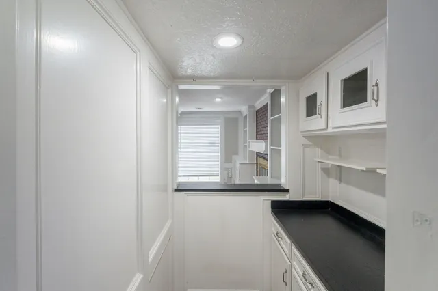 a kitchen with granite countertop a stove a sink and cabinets