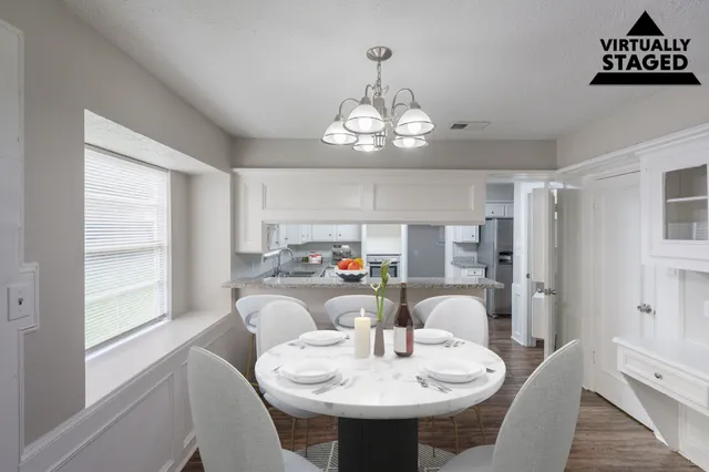a view of a dining room with furniture a chandelier and wooden floor