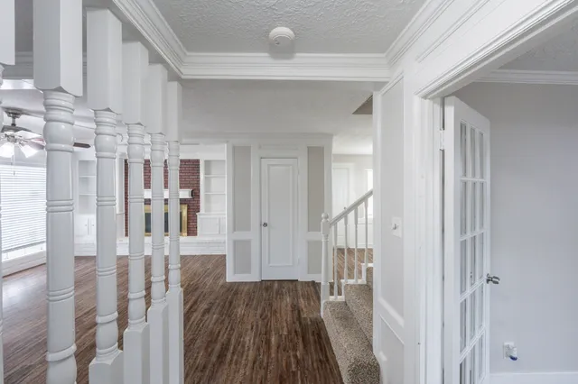 a view of a hallway with wooden floor and staircase