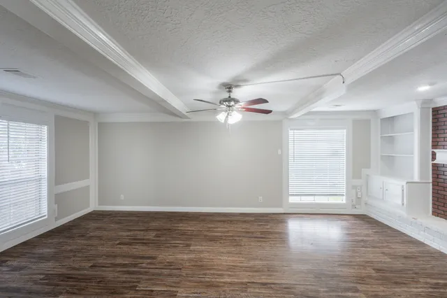 wooden floor in an empty room with a window
