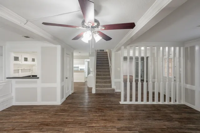 a view of a livingroom with wooden floor and an entryway