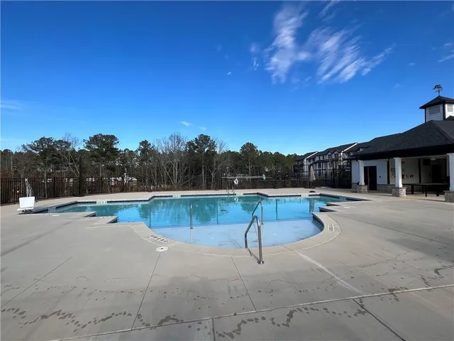 a view of a house with swimming pool and sitting area