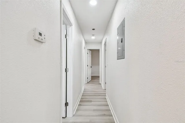 an empty room with wooden floor ceiling fan and windows