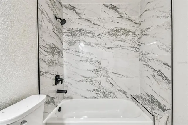 an empty room with a window and a ceiling fan