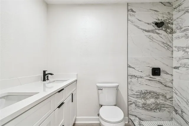 a view of an empty room with wooden floor fireplace and a window