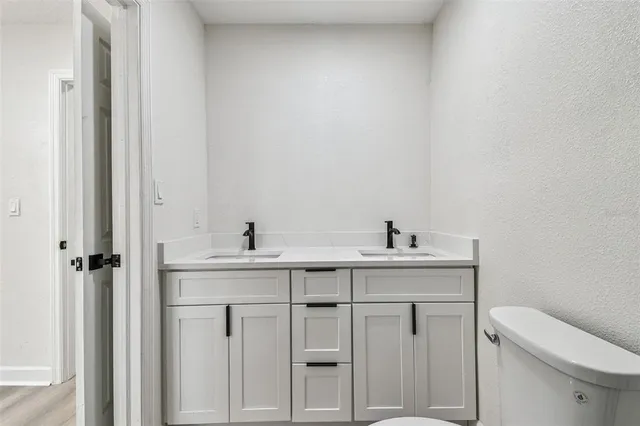 an empty room with wooden floor fireplace and windows