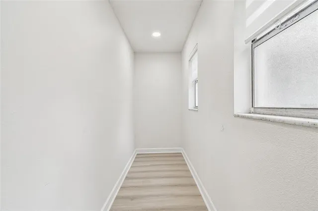a view of an empty room with a fireplace and a window