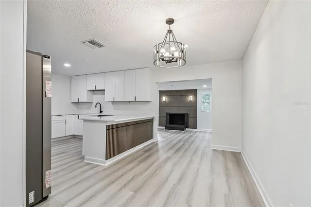 a kitchen with white cabinets sink and white stainless steel appliances