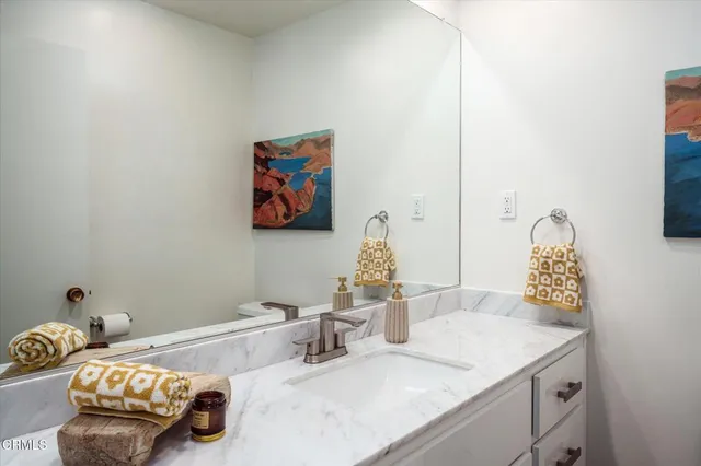 a bathroom with a granite countertop sink and a mirror
