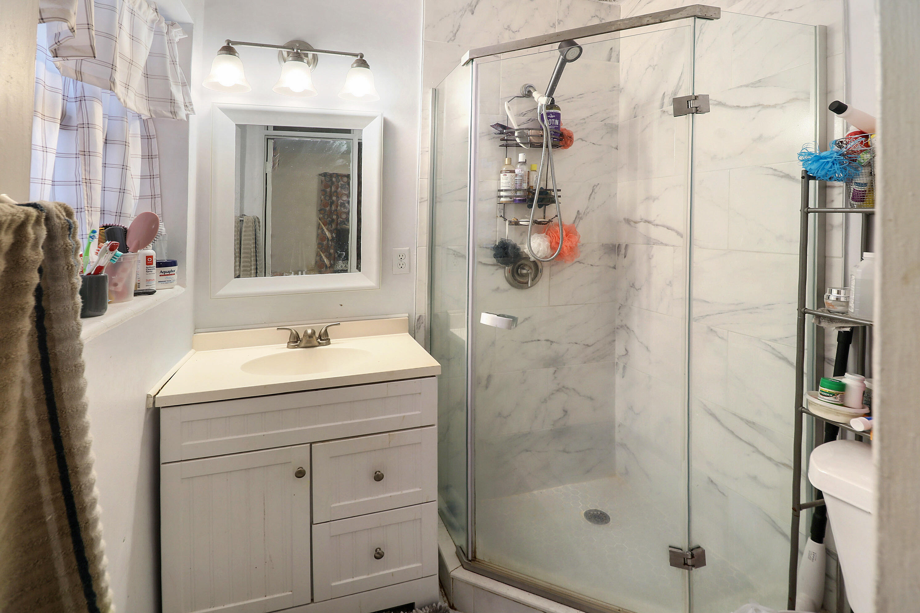 4710 Northwest 11th Place Lauderhill, FL 33313 - Photo 10 of 12 a bathroom with a shower sink and mirror
