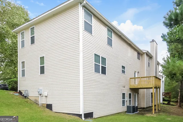 a view of a white house next to a yard