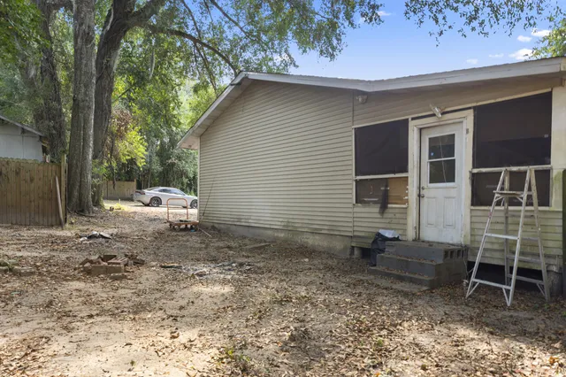 an aerial view of residential houses with outdoor space and trees