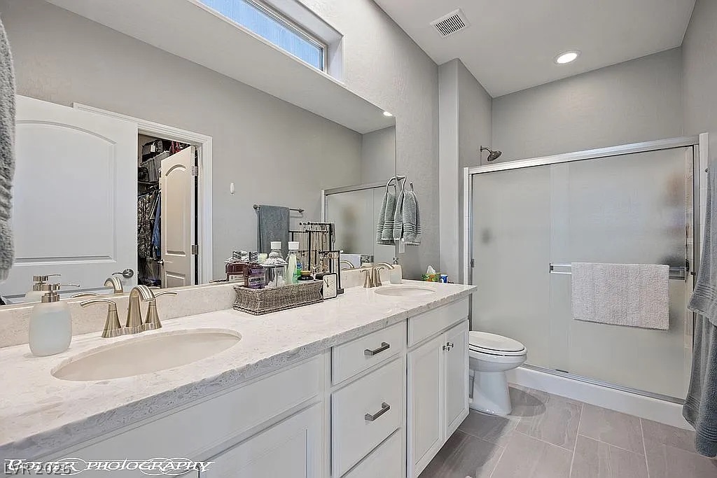 1304 Cottage Ridge Mesquite, NV 89034 - Photo 17 of 52 Double vanities and a spacious shower elevate this well-appointed primary bathroom.
