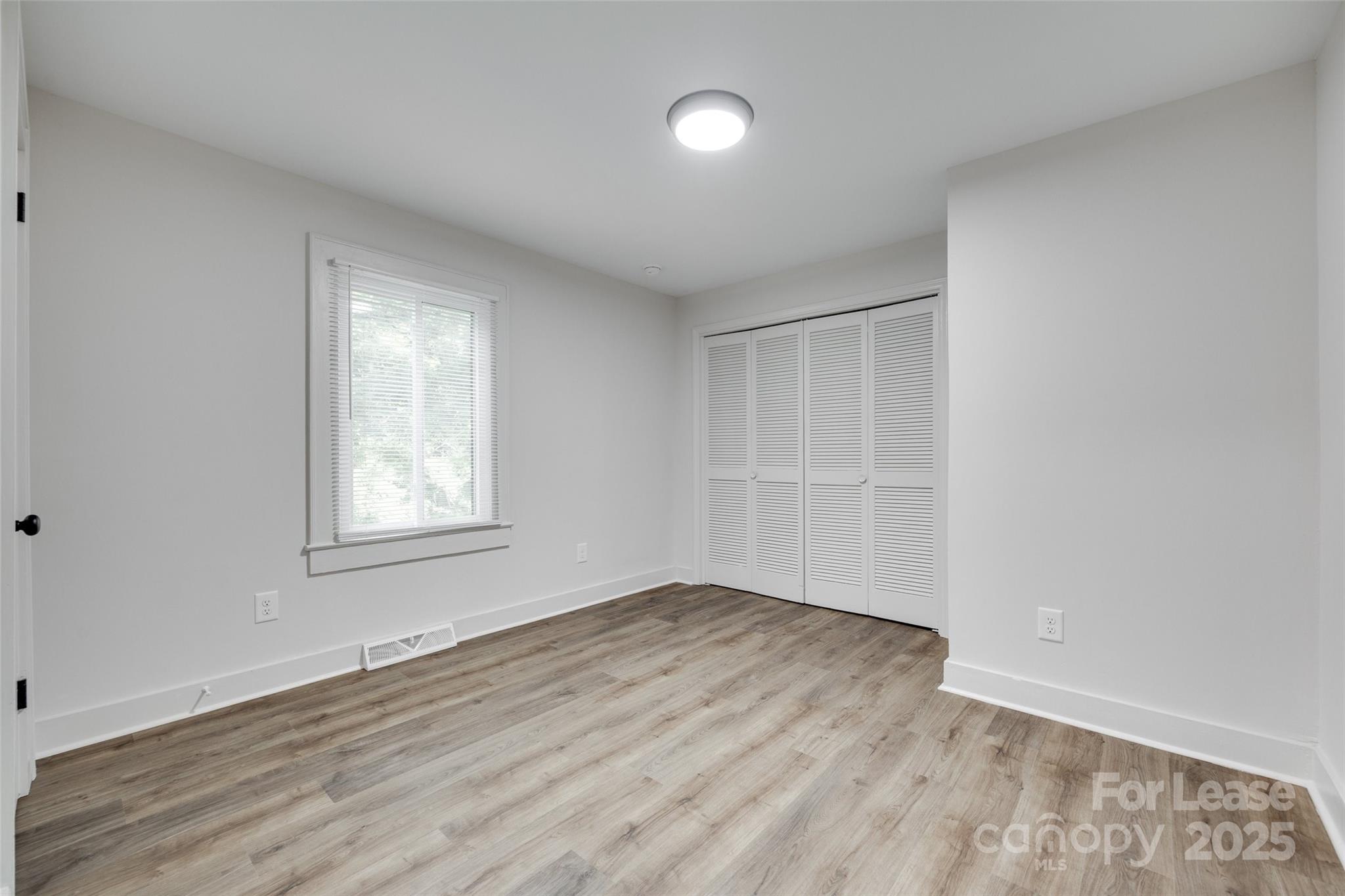 3113 E Highway, Unit 218 Monroe, NC 28110 - Photo 19 of 27 an empty room with wooden floor and windows