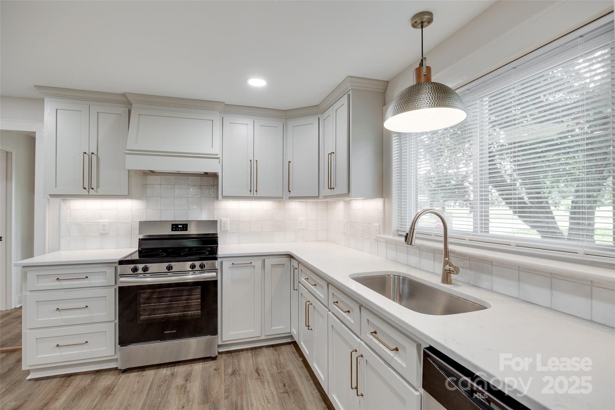 3113 E Highway, Unit 218 Monroe, NC 28110 - Photo 9 of 27 a kitchen with stainless steel appliances a stove a sink and a wooden floor