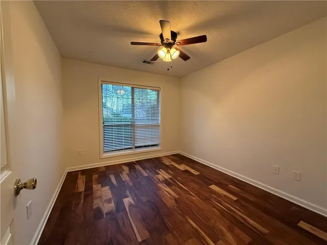 a view of wooden floor and a chandelier fan in a room