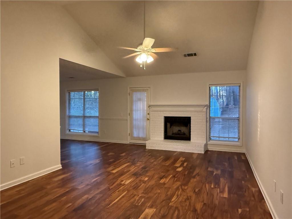 3284 Saddlegate Court Buford, GA 30519 - Photo 5 of 22 a view of an empty room with wooden floor fireplace and a window