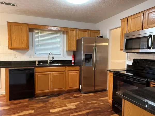 a kitchen with granite countertop stainless steel appliances and wooden cabinets
