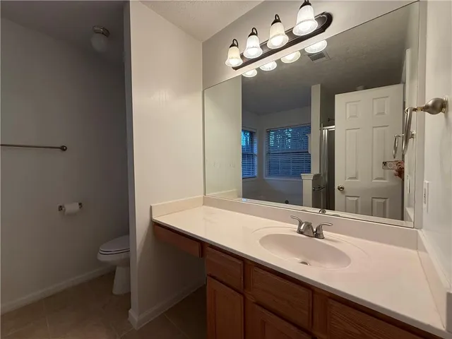 a bathroom with a sink a toilet and a mirror