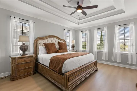 a bedroom with a large bed and a chandelier fan