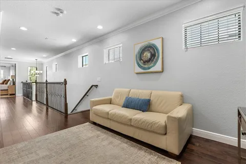 a living room with couches and a view of kitchen
