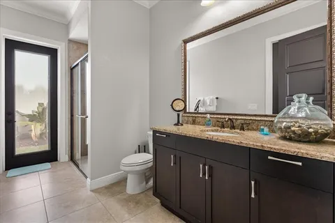 a bathroom with a granite countertop sink a toilet and a mirror