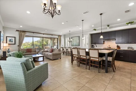 a living room with furniture kitchen and a chandelier
