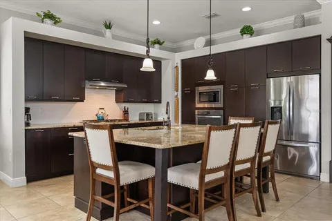 a kitchen with a dining table chairs and refrigerator