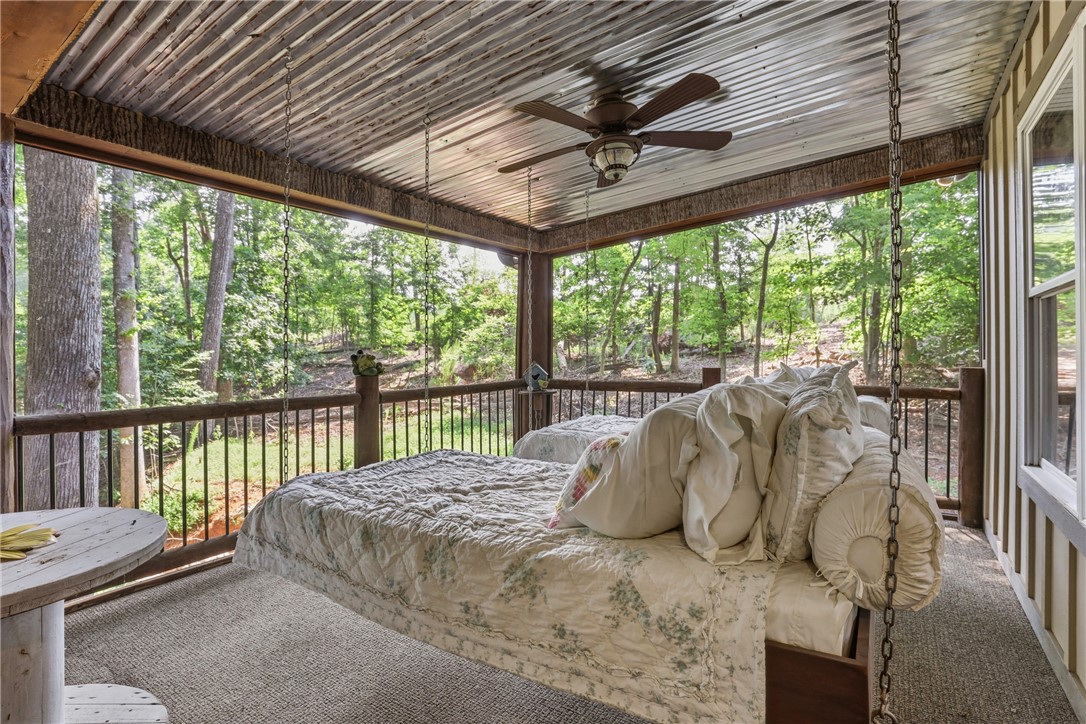 1110 Sunset Lane Anderson, SC 29626 - Photo 22 of 38 An inviting screened porch features a hanging bed and a ceiling fan, perfect for shaded outdoor repose.