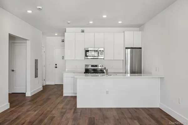 a kitchen with stainless steel appliances granite countertop a refrigerator a stove and a sink