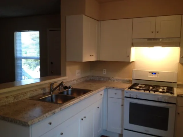 a kitchen with stainless steel appliances granite countertop a sink a stove and a microwave