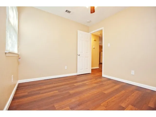 a view of an empty room with wooden floor