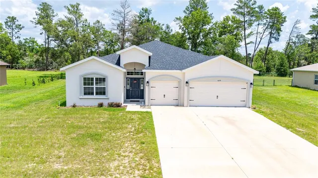 a view of a house with a yard and trees