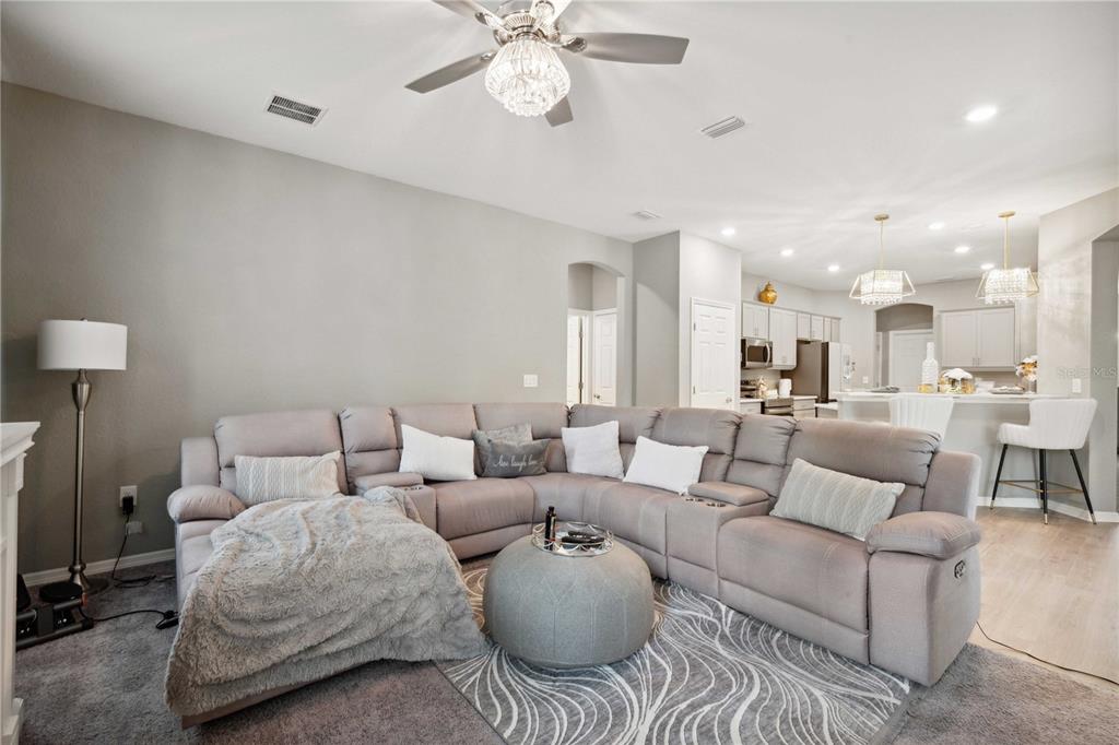 5239 Southwest 114th Street Road Ocala, FL 34476 - Photo 13 of 42 a living room with furniture kitchen view and a chandelier