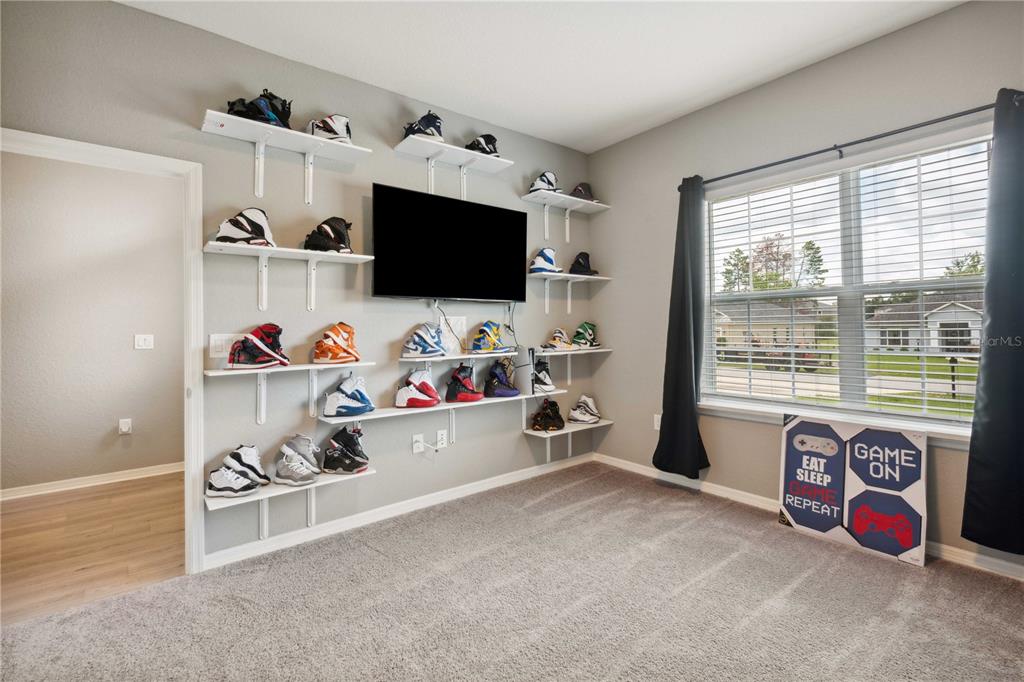 5239 Southwest 114th Street Road Ocala, FL 34476 - Photo 24 of 42 a living room with furniture and a flat screen tv
