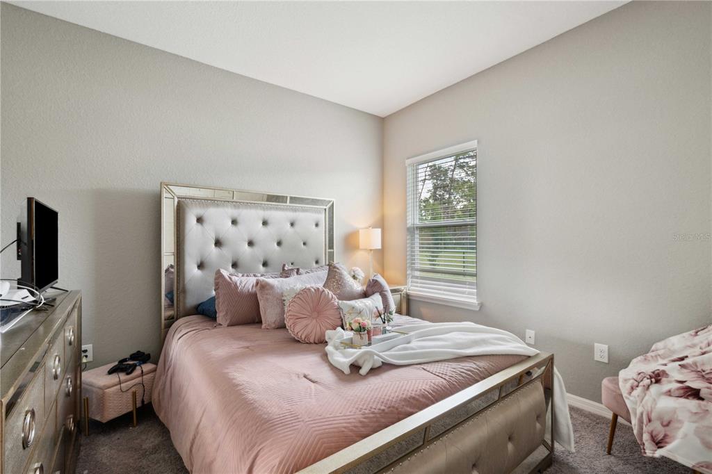 5239 Southwest 114th Street Road Ocala, FL 34476 - Photo 26 of 42 a bedroom with a bed and flat screen tv