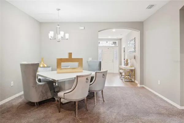 a view of a dining room with furniture and chandelier