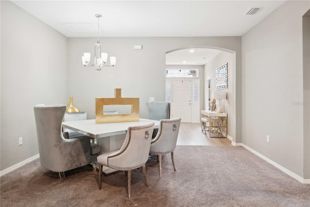 5239 Southwest 114th Street Road Ocala, FL 34476 - Photo 3 of 42 a view of a dining room with furniture and chandelier