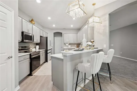 a kitchen with stainless steel appliances kitchen island granite countertop a sink and a refrigerator